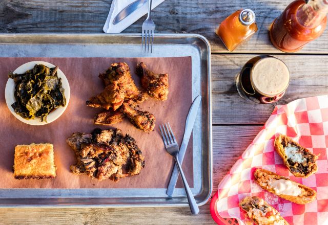 Brew N Que tray of chicken, spinach, cornbread and pulled pork with beer and potato skins on the side